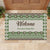A custom doormat featuring a green Fijian Tribal Tapa pattern with a personalized family name at the center